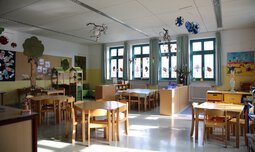 Gruppenzimmer mit Tischen und Stühlen | © Caritas München und Oberbayern